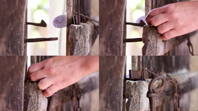 女性手用铁锁关闭旧木门