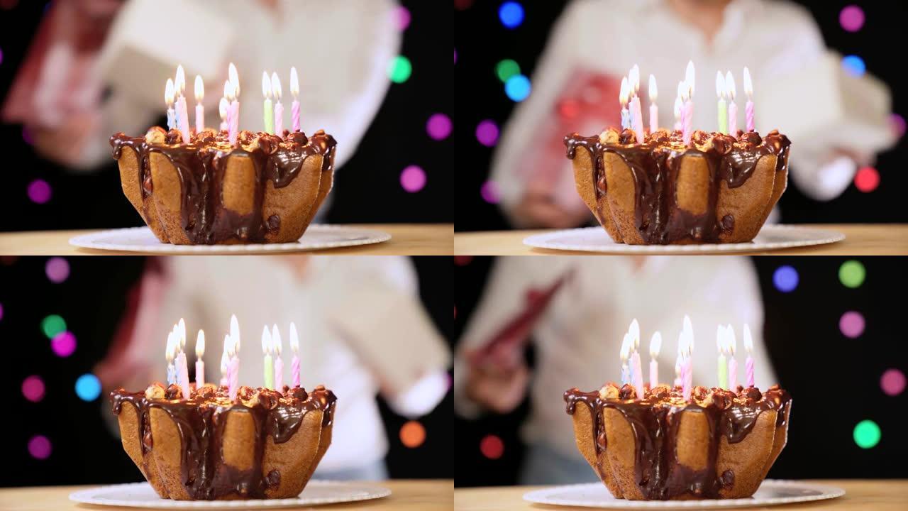 快乐的人在巧克力生日蛋糕前跳舞。生日心情，男人用礼物庆祝生日