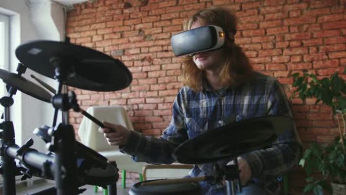 年轻的红发男子音乐家在家里用虚拟现实眼镜演奏电鼓，慢动作