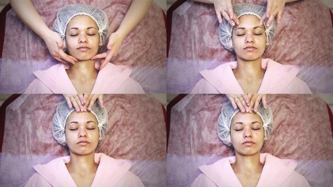 非裔美国妇女在水疗沙龙接受面部按摩