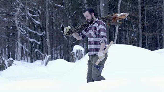 男人带着原木在雪地里行走