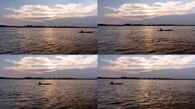 多云的日出下河上的小渔夫独木舟