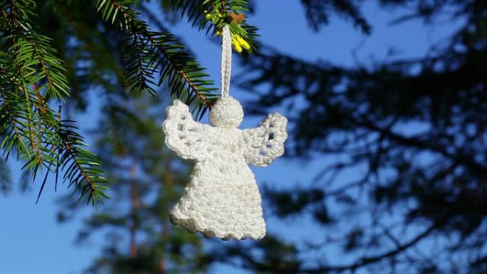 森林云杉上的白色圣诞钩针天使