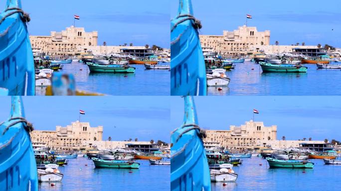 美丽的凯特湾城堡从地中海在亚历山大港，埃及。蓝蓝的天空下，城堡前有很多渔船。