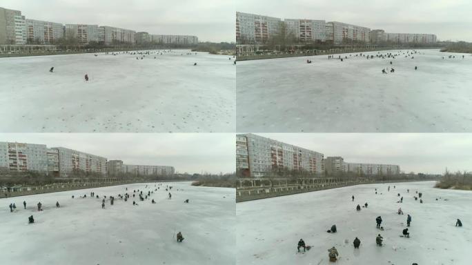 河的鸟瞰图，冰上的渔民。阴天的冬日。乌克兰能源公司。4k视频