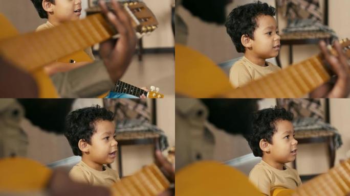 模仿弹吉他和唱歌的混血儿小男孩