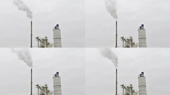 灰色天空上工厂烟囱冒烟