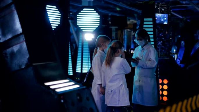 年轻的科学家正在一个技术实验室里交谈。包括聚光灯、工作设备和电器。