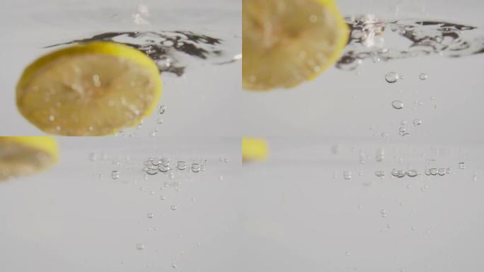 一片柠檬在清澈的水中落下慢动作