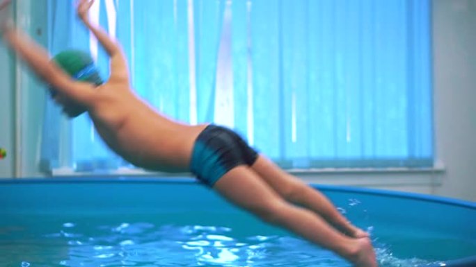 游泳池里那个戴着泳镜的男孩跳入水中。