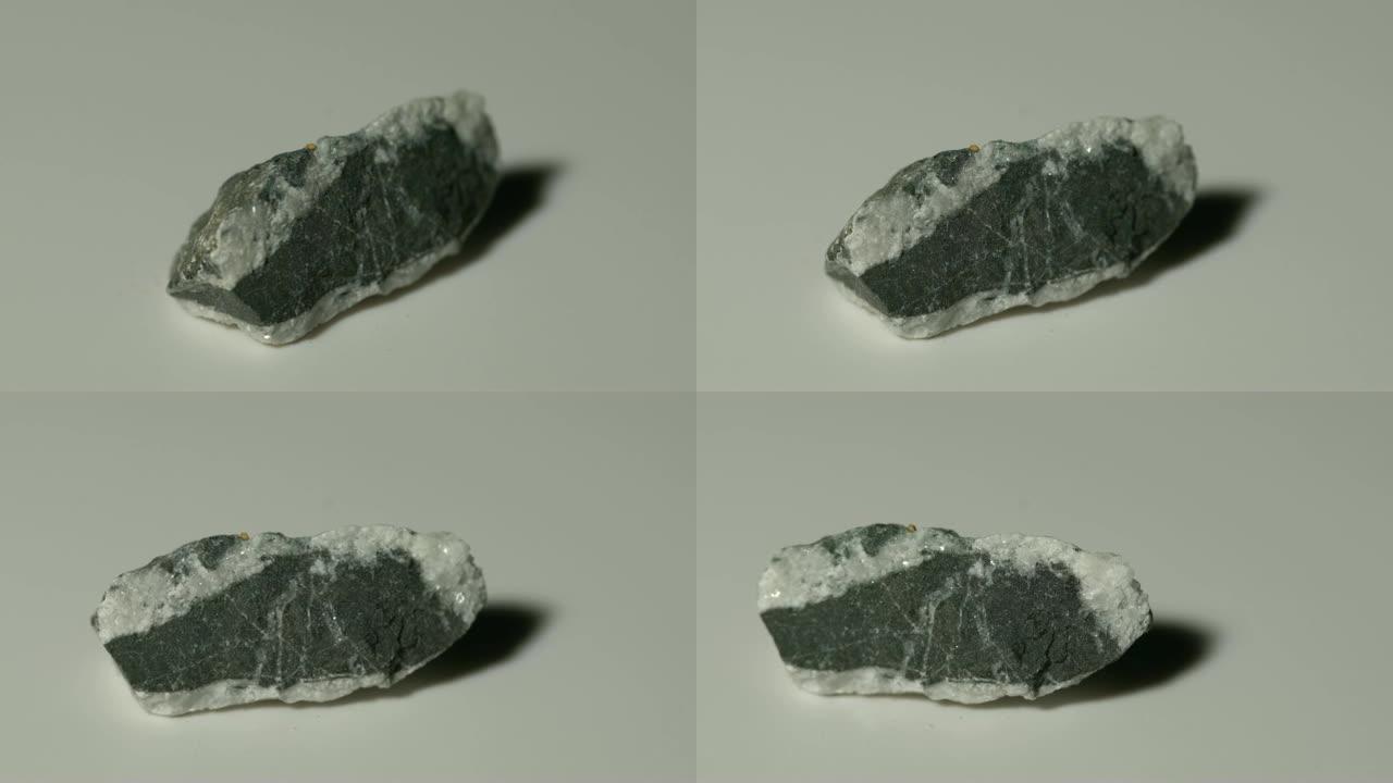白色背景旋转的碳质石灰石矿物样品