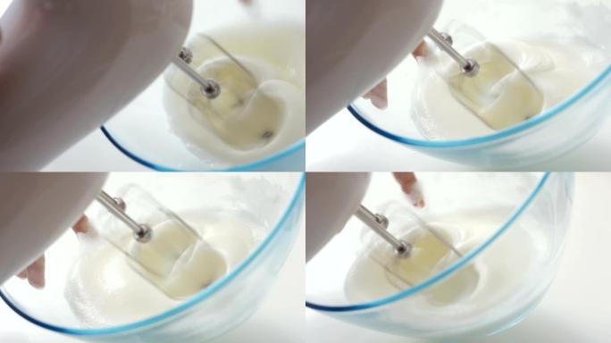 用电动搅拌器搅打蛋清在玻璃碗中制作提拉米苏奶油