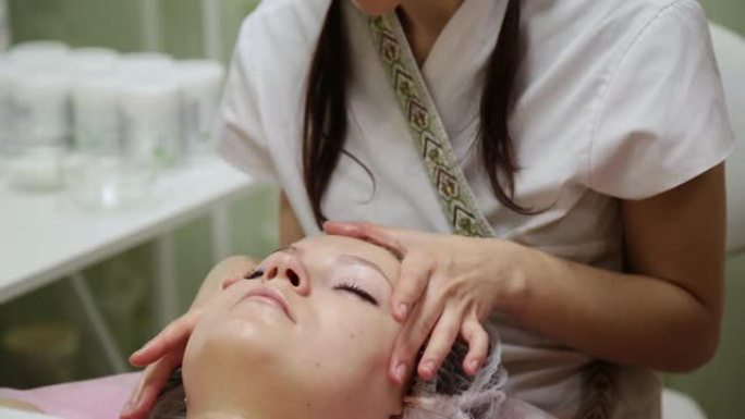 水疗女性面部按摩。美容水疗沙龙的面部按摩。女性在美容水疗中心享受放松的面部按摩。身体护理，皮肤护理，