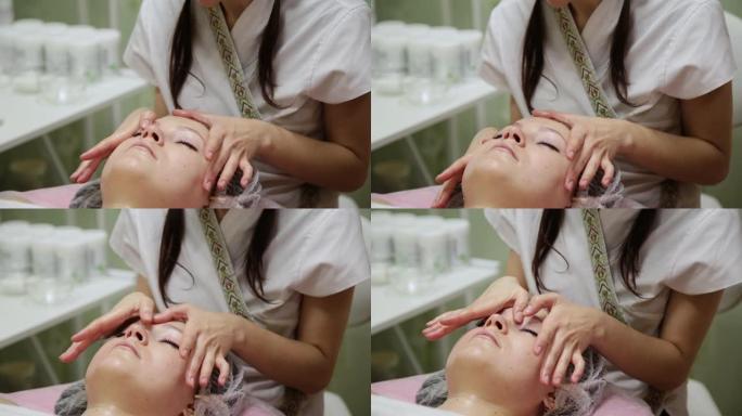 水疗女性面部按摩。美容水疗沙龙的面部按摩。女性在美容水疗中心享受放松的面部按摩。身体护理，皮肤护理，