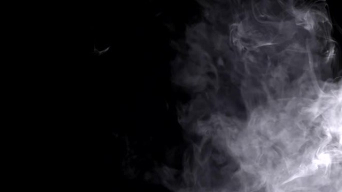 特写镜头在空气中传播白色烟雾黑色覆盖物运动全黑背景和美丽填充黑暗工作室