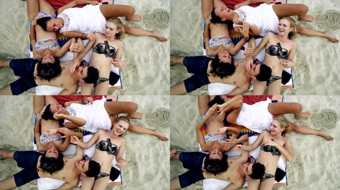 一群朋友躺在沙滩上玩得开心的俯视图肖像