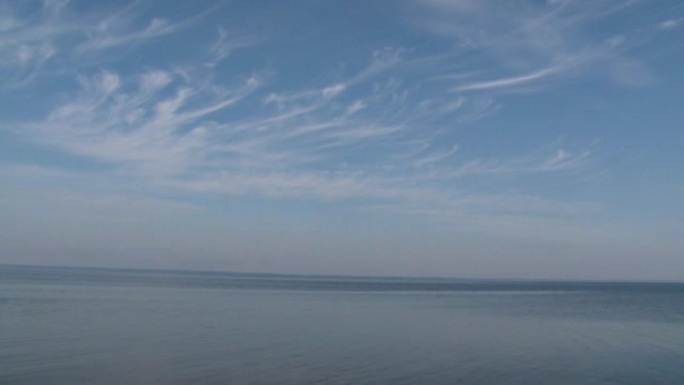 天空多云的河流或湖泊景观。夏季平静水的波纹面