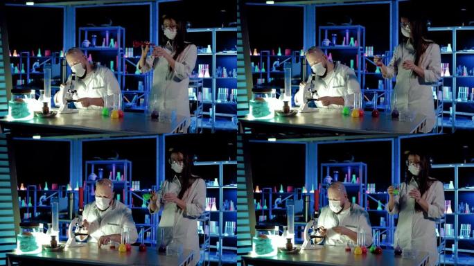 化学家和一名助手进行科学实验。科学家将移液管滴到玻璃杯上，然后在显微镜下观察反应。