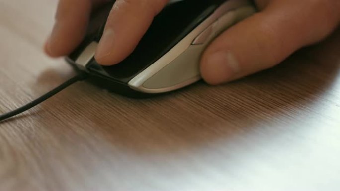 男人用手点击电脑鼠标。手里拿着鼠标的商人。特写。
