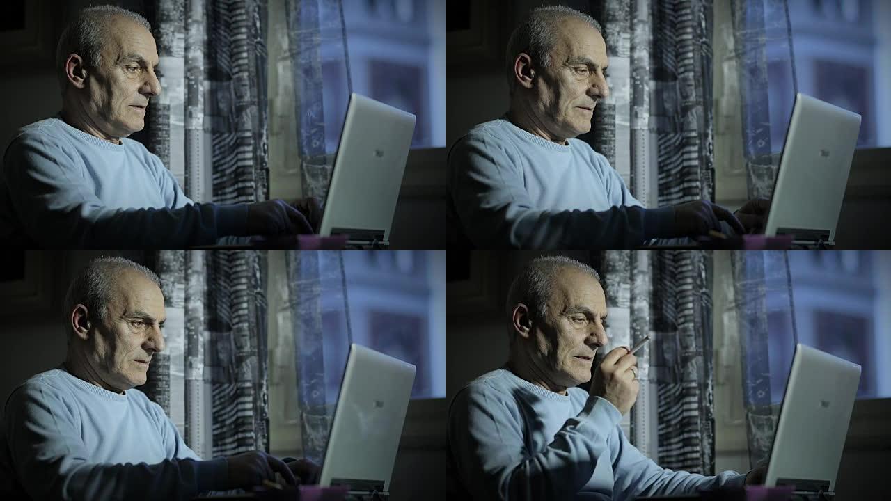 老人深夜抽烟时在电脑上工作