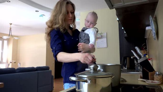 带着孩子的母亲混合锅。厨房准备晚餐。4K