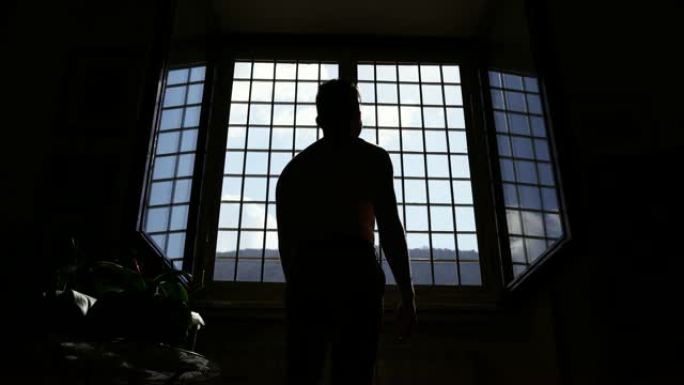 囚犯在牢房里透过金属栅格注视着自由。可悲的遗憾，监狱单独监禁。精神病院囚犯的剪影