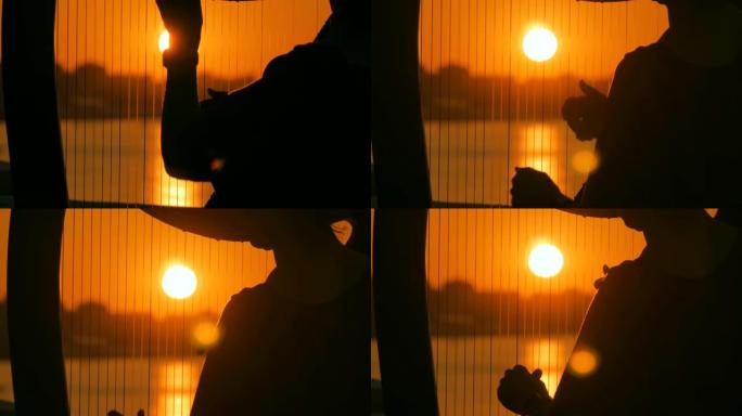 日落时弹奏竖琴的女人剪影