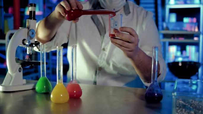 科学家将液体从一个烧瓶倒入另一个烧瓶。显微镜和装有液体的烧杯站在化学实验室的桌子上。