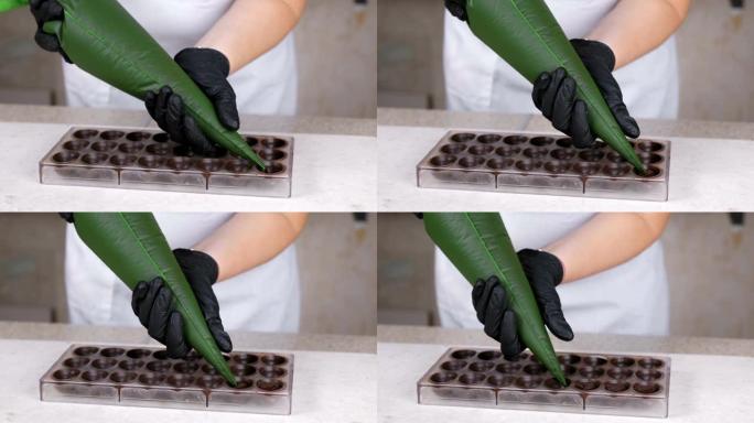 贝克的手从糕点袋中倒出液态巧克力填充果仁糖。