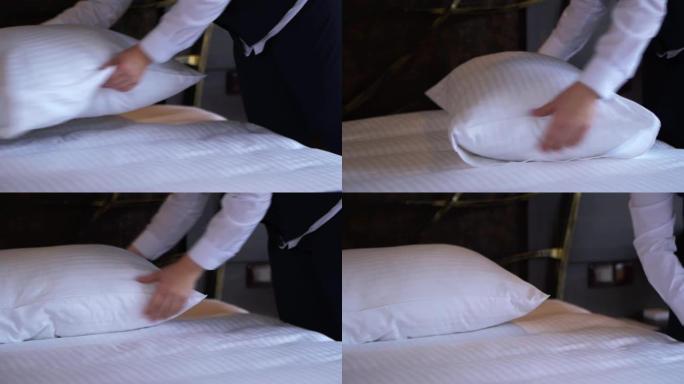 酒店清洁女工在一个舒适的小酒店房间里拉直枕头。