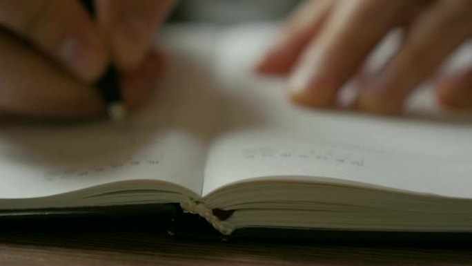 一个人翻过日记的空白页。商人在笔记本上做笔记。