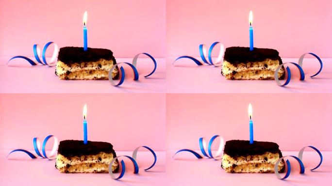 提拉米苏蛋糕，粉色背景和五彩纸屑上燃烧着蓝色蜡烛