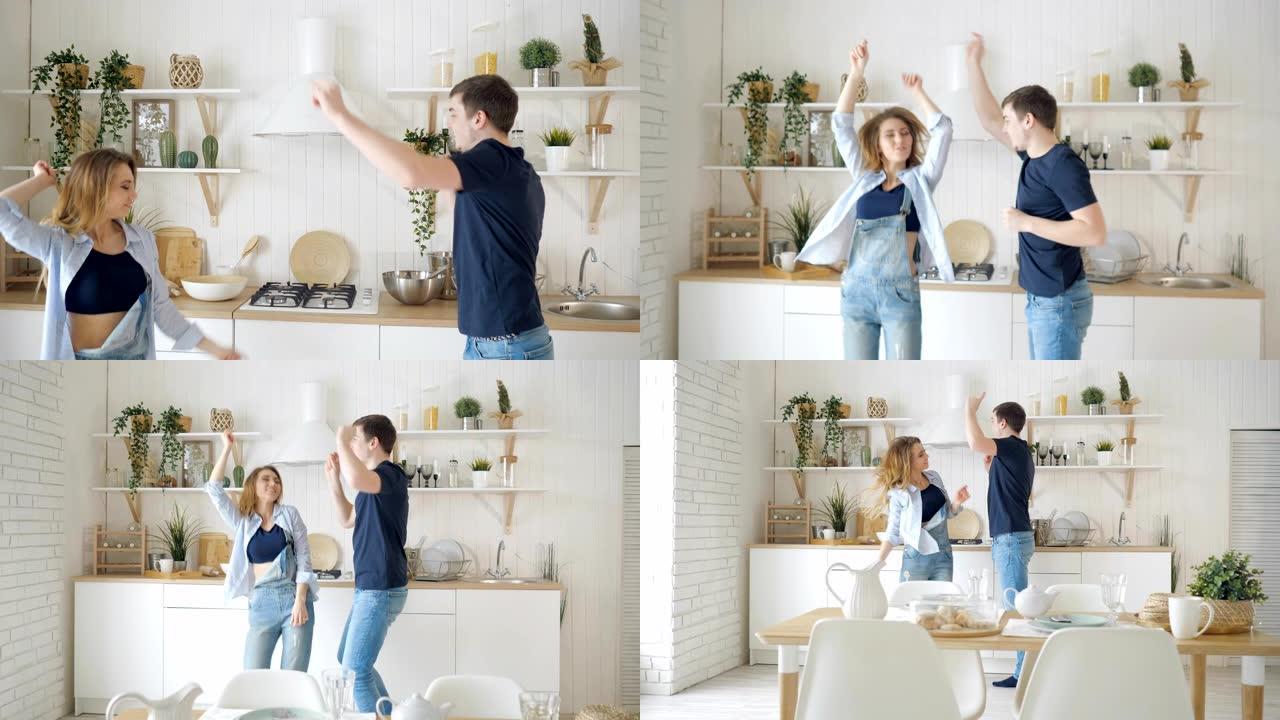 快乐的男人女人在现代厨房的餐桌旁跳舞