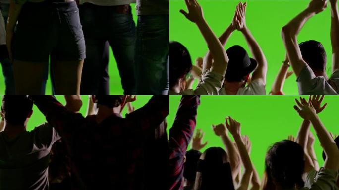 一群粉丝在绿屏上跳舞。音乐会，跳跃，跳舞。慢动作。在红色史诗电影相机上拍摄。