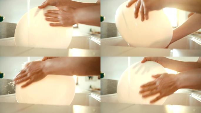 4k镜头: 女人打开水并用手冲洗白板。家务概念。