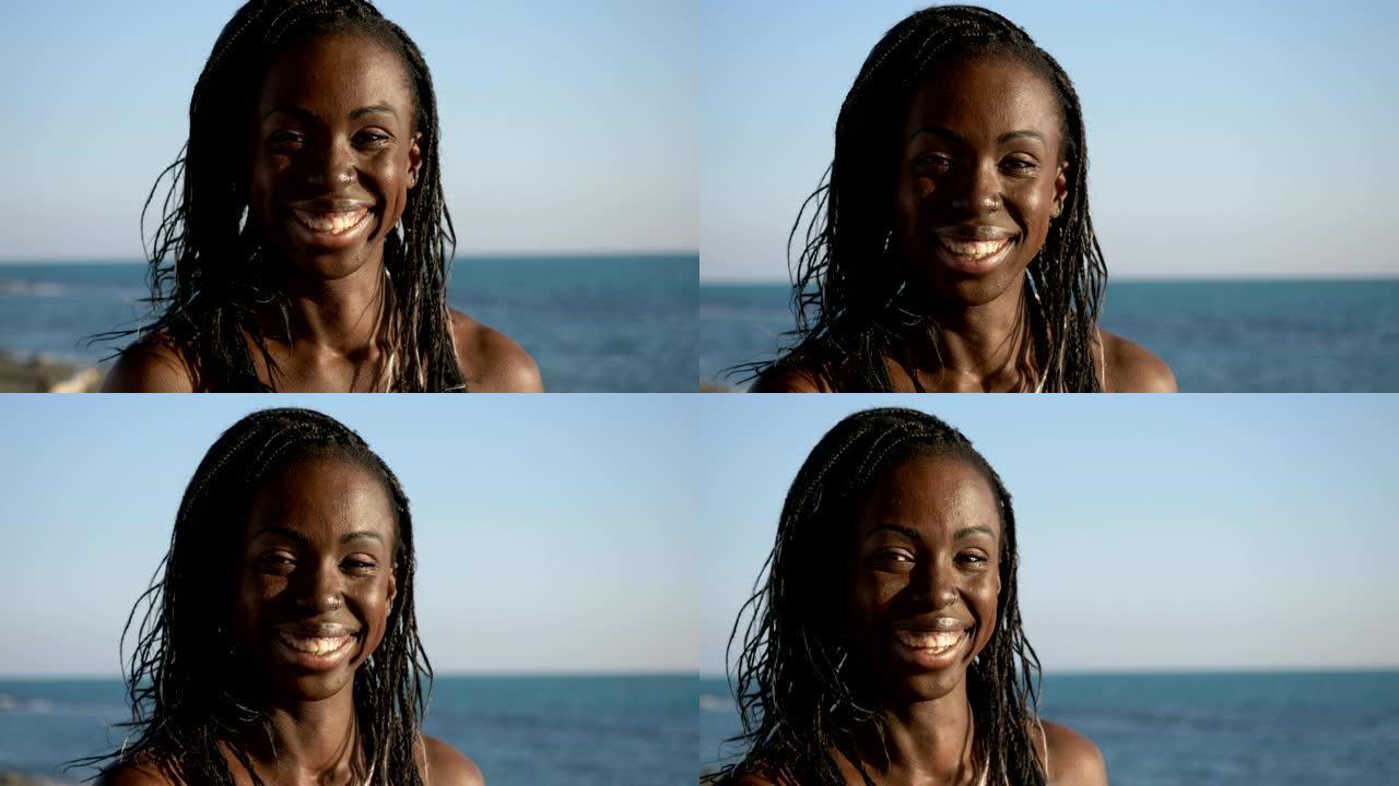 迷人的快乐黑人美国女人在海滩上，转身对着镜头微笑