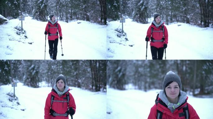 年轻的白人妇女在积雪覆盖的树林中徒步旅行。回首