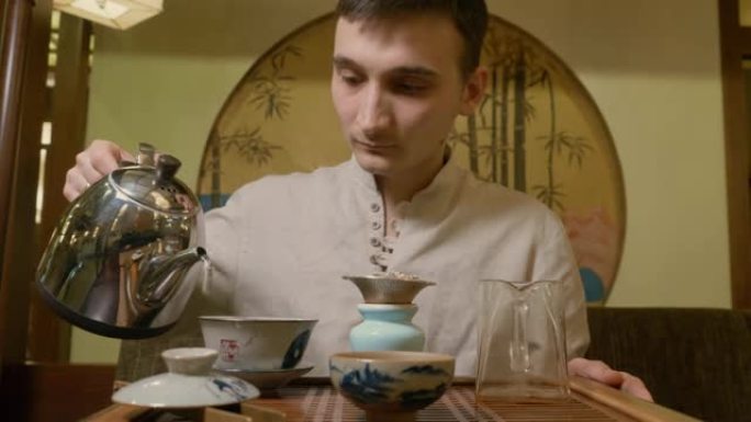 茶师将热水从水壶倒入盖湾以冲泡仪式上的茶