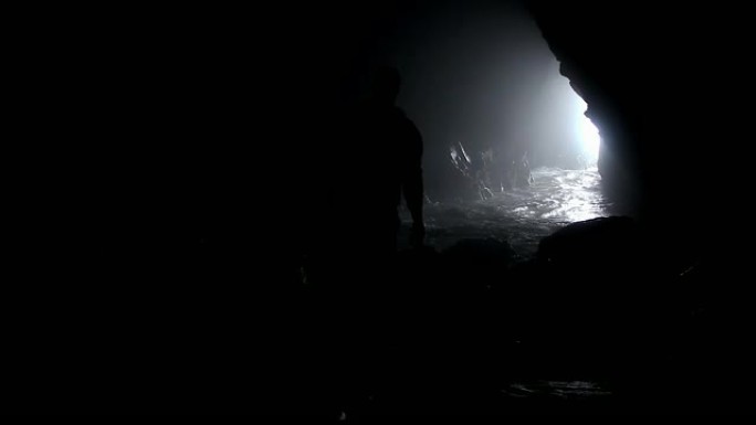 在海洞上走向水面的人的剪影