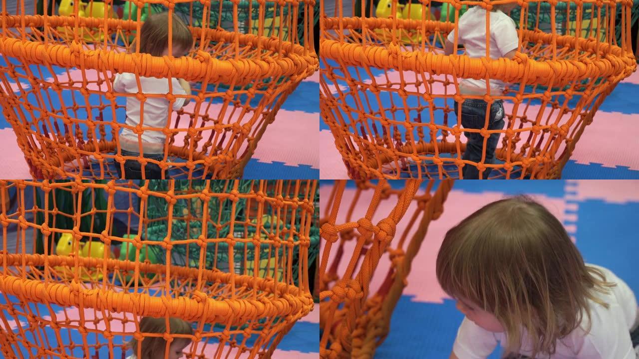 儿童游戏中心的小可爱女孩爬上绳索