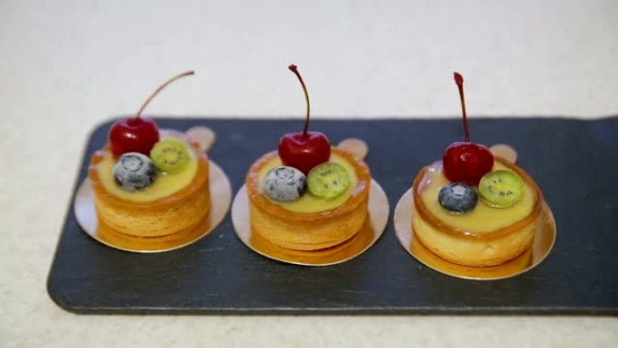 一排排用蜂蜜和浆果装饰的樱桃和柠檬纸杯蛋糕