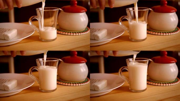 一个人将牛奶倒入木桌上的玻璃杯中。盘子里的奶酪。慢动作。