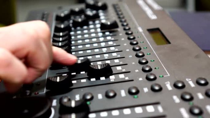 男性手使用混音控制台，录音棚混音台，配有工程师或音乐制作人