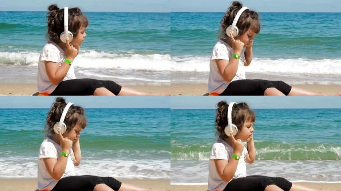 孩子在海滩上戴着耳机听音乐。