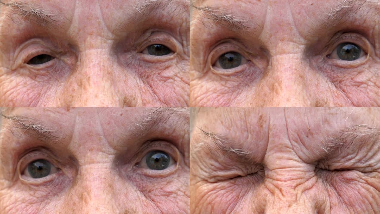 成熟女人的肖像拧起灰色的眼睛，然后睁开。关闭老祖母皱着皱纹的脸，带着悲伤的景象看着镜头。高级女士的悲