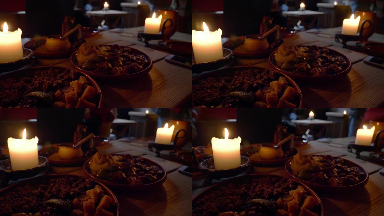 复古复古蜡烛灯和中世纪食物在黑暗中的木制桌子上