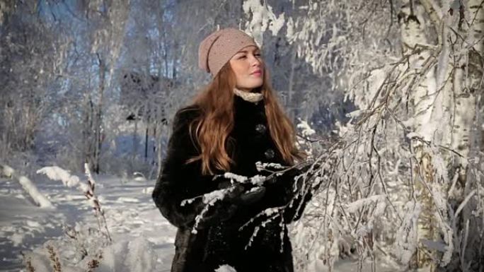 一个美丽的女人的特写很开心，冬天在公园里散步