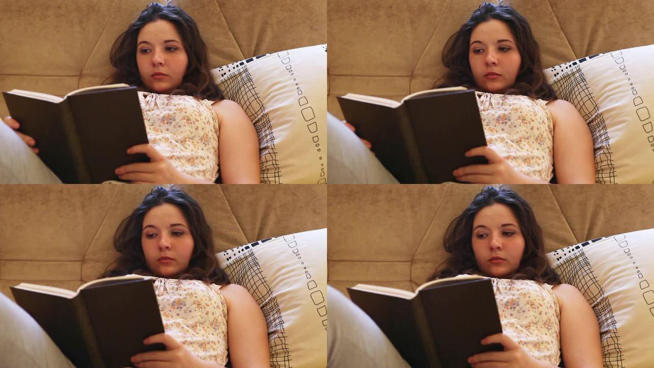 女孩躺在床上，手里拿着纸质书看书