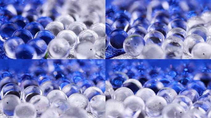 水凝胶球在蓝色和银色表面上旋转。特写宏。