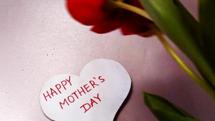 心型贺卡，上面写着母亲节快乐，红色郁金香带着感激